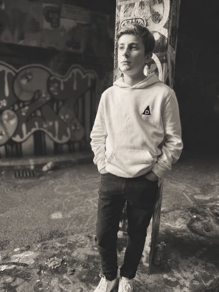 Front view of boy wearing The Decried beige hoodie
