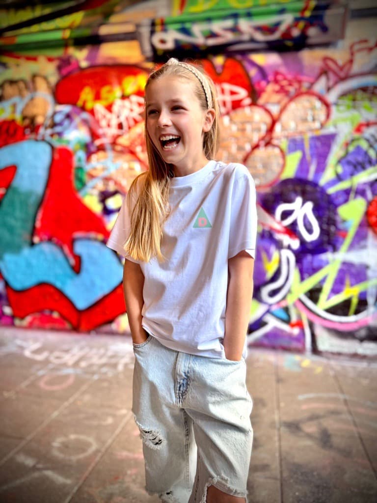 Laughing girl wearing The Decried white mini tee