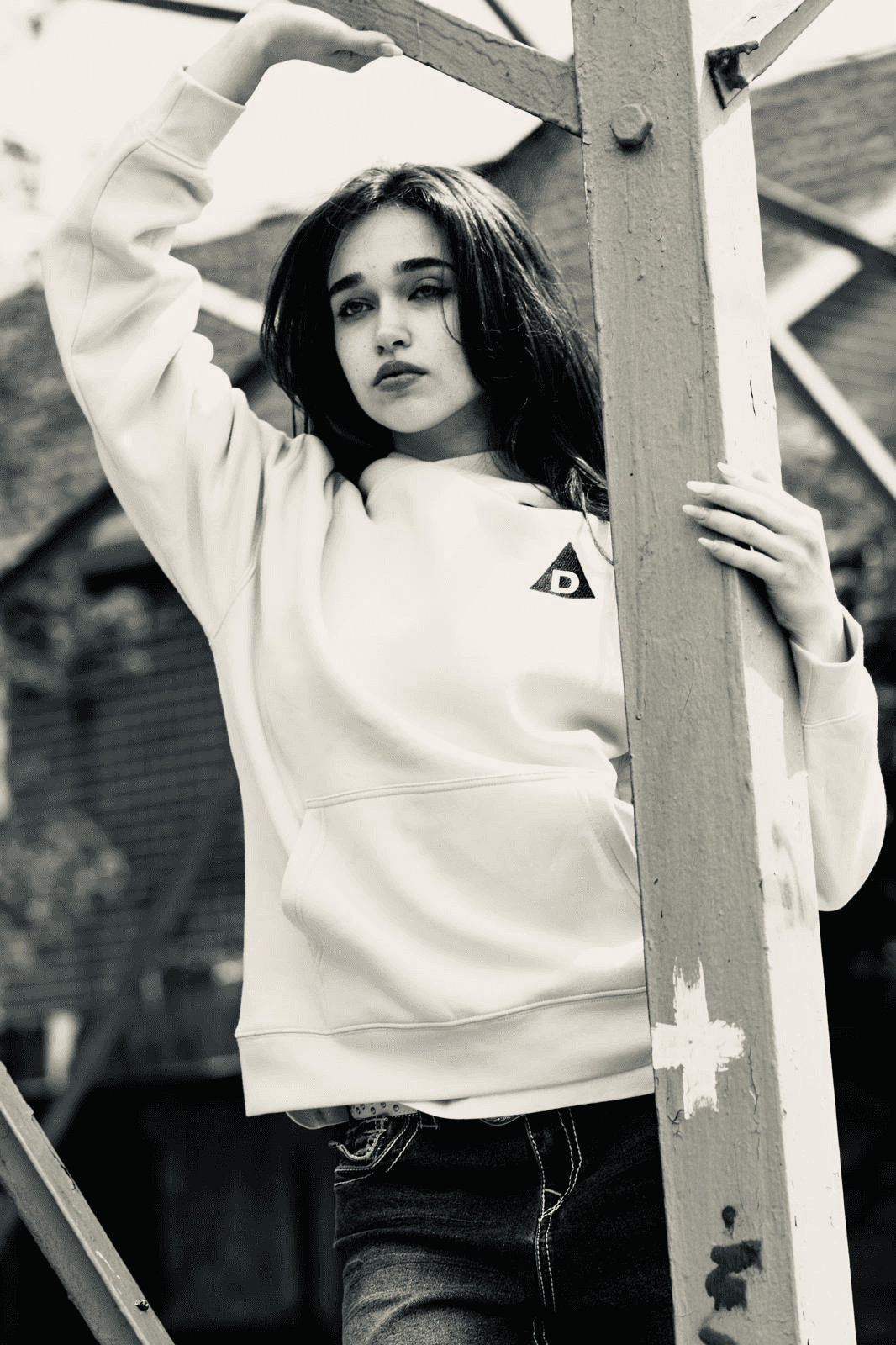 Front view of woman wearing The Decried beige hoodie