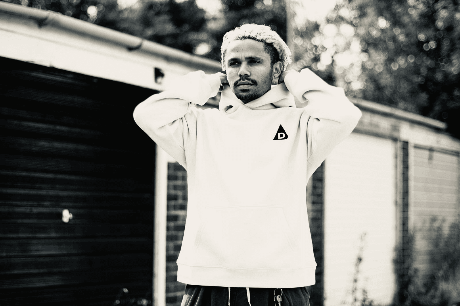 Front view of man wearing The Decried beige hoodie