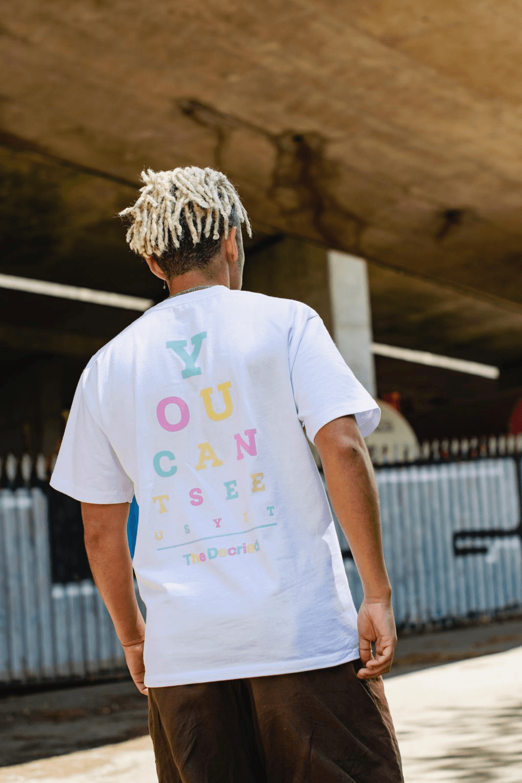 Back view of man wearing The Decried white tee